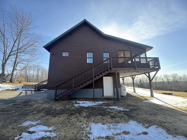 1083 N Rd, Ripley, ME 04930 - snow covered back of property featuring a wooden deck and stairs
