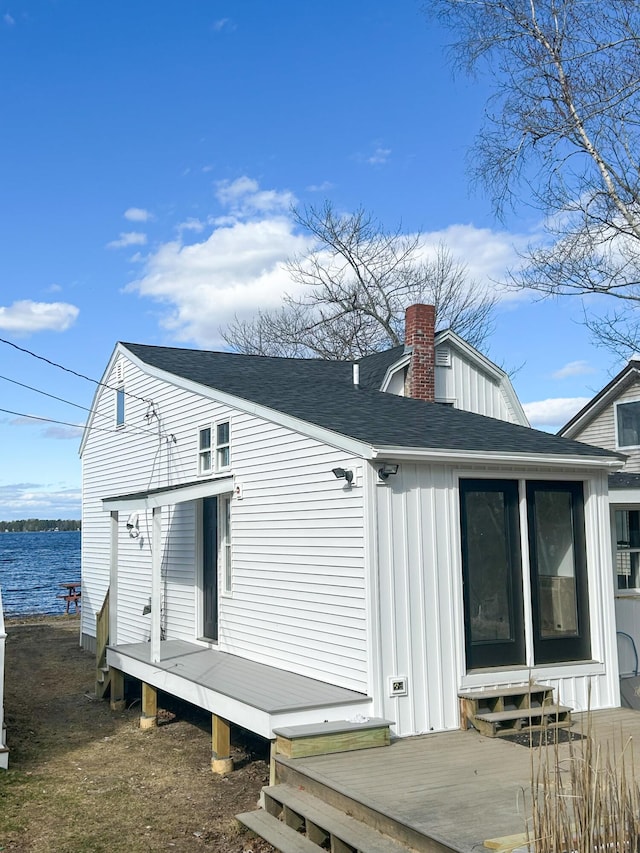 108/9 113 Sandy Beach Rd, Glenburn, ME 04401 - rear view of house featuring a chimney, a deck, board and batten siding, roof with shingles, and a sunroom