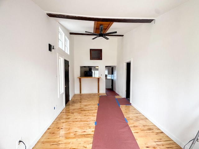 108/9 113 Sandy Beach Rd, Glenburn, ME 04401 - hallway featuring a towering ceiling, light wood finished floors, beam ceiling, and baseboards