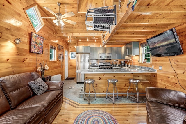 108/9 113 Sandy Beach Rd, Glenburn, ME 04401 - kitchen with stainless steel appliances, open floor plan, wooden ceiling, wood walls, and a peninsula