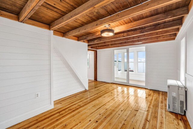 108/9 113 Sandy Beach Rd, Glenburn, ME 04401 - unfurnished living room with a wood ceiling with exposed beams, light wood-style floors, heating unit, plenty of natural light, and wood walls