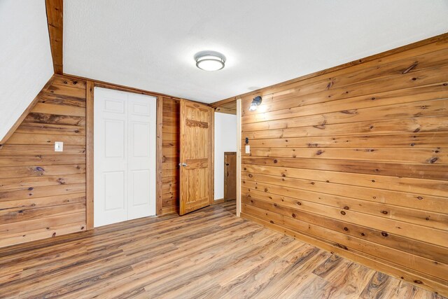 108/9 113 Sandy Beach Rd, Glenburn, ME 04401 - unfurnished bedroom with wooden walls, light wood-type flooring, and a closet