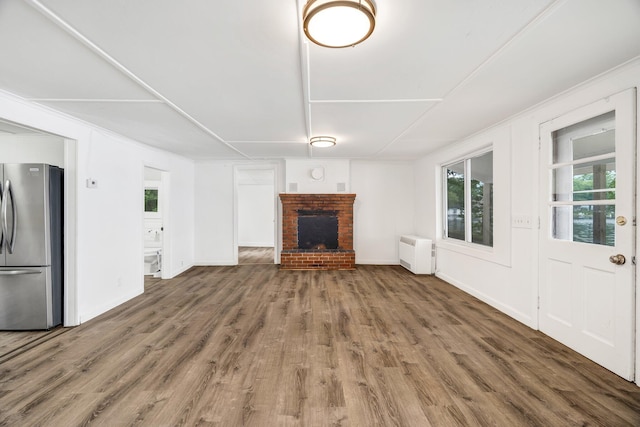 108/9 113 Sandy Beach Rd, Glenburn, ME 04401 - unfurnished living room featuring wood finished floors, plenty of natural light, and a fireplace