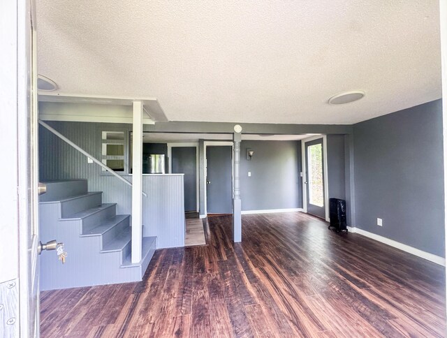 108/9 113 Sandy Beach Rd, Glenburn, ME 04401 - unfurnished living room featuring a textured ceiling, wood finished floors, and stairs