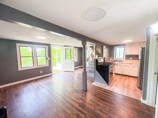 108/9 113 Sandy Beach Rd, Glenburn, ME 04401 - kitchen featuring open floor plan, appliances with stainless steel finishes, light countertops, wood finished floors, and white cabinetry