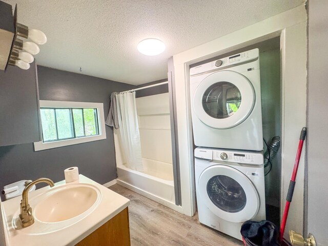 108/9 113 Sandy Beach Rd, Glenburn, ME 04401 - full bathroom with stacked washing machine and dryer, a textured ceiling, wood finished floors, shower / bath combination with curtain, and vanity