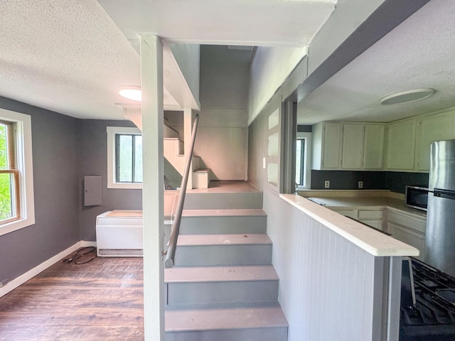 108/9 113 Sandy Beach Rd, Glenburn, ME 04401 - stairway featuring a textured ceiling, healthy amount of natural light, and wood finished floors