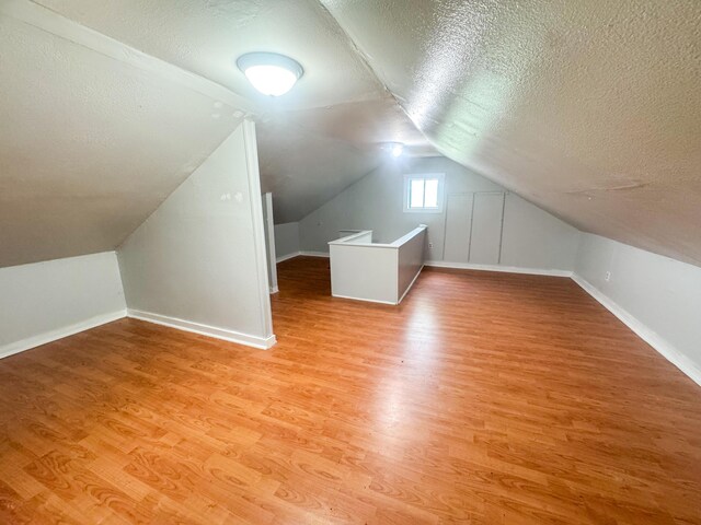 108/9 113 Sandy Beach Rd, Glenburn, ME 04401 - bonus room featuring a textured ceiling, light wood-type flooring, and lofted ceiling