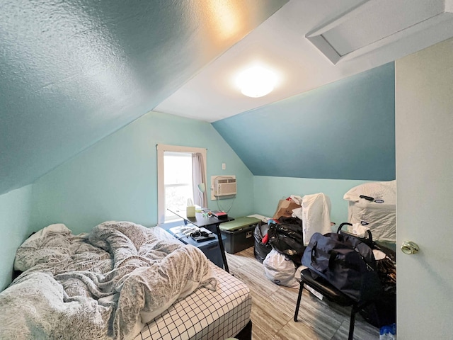 1716 Main St, Mapleton, ME 04757 - bedroom with wood finished floors, a wall mounted air conditioner, attic access, and vaulted ceiling