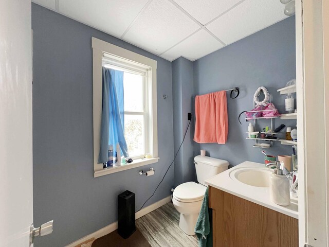 1716 Main St, Mapleton, ME 04757 - bathroom with vanity, a paneled ceiling, baseboards, toilet, and wood finished floors