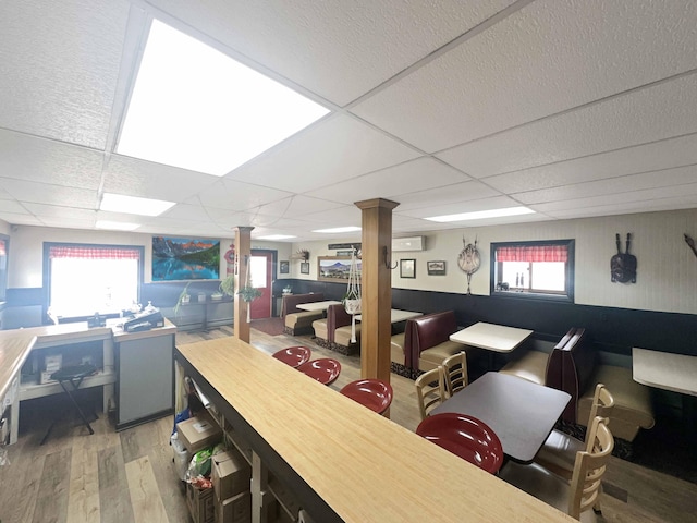 1716 Main St, Mapleton, ME 04757 - bar with ornate columns, a drop ceiling, a wall unit AC, and wood finished floors