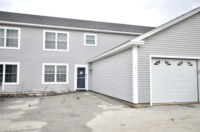 view of front of house with a shingled roof and a garage
