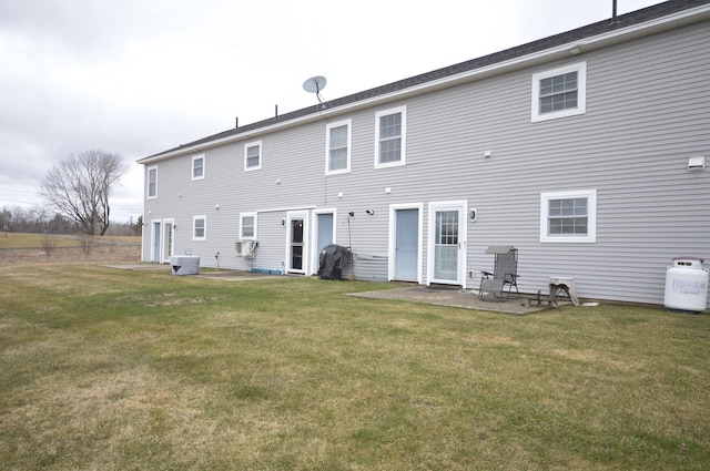 rear view of house with a patio, central air condition unit, and a lawn