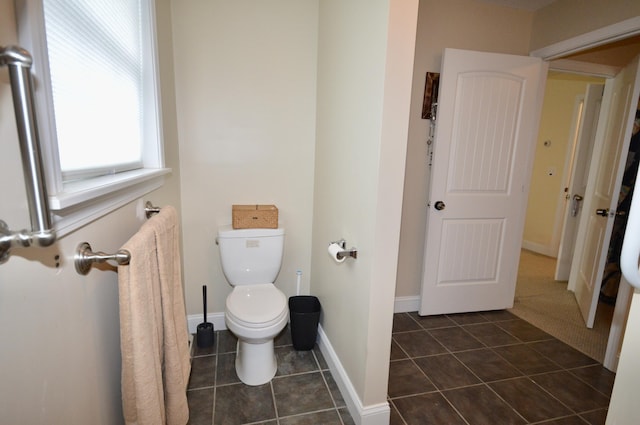 bathroom with toilet, tile patterned floors, and baseboards
