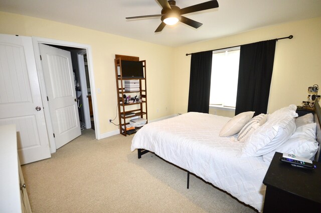 bedroom featuring light carpet, baseboards, and a ceiling fan