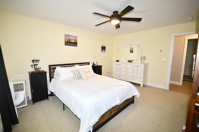 bedroom with radiator heating unit, light colored carpet, baseboards, and a ceiling fan