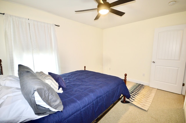 carpeted bedroom featuring baseboards and ceiling fan