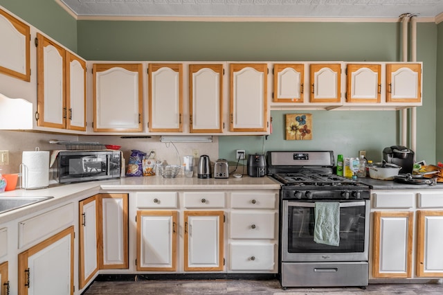 kitchen featuring crown molding, light countertops, and stainless steel gas stove