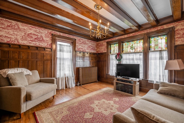 living area featuring radiator, a notable chandelier, and wallpapered walls