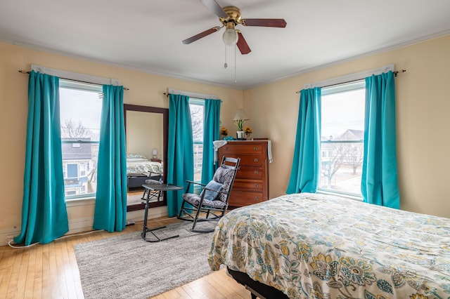 bedroom featuring ornamental molding, ceiling fan, and hardwood / wood-style flooring