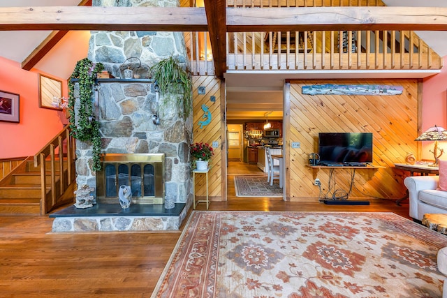 252 General Turner Hill Rd, Turner, ME 04282 - living area with a fireplace, stairway, wood walls, beam ceiling, and wood finished floors