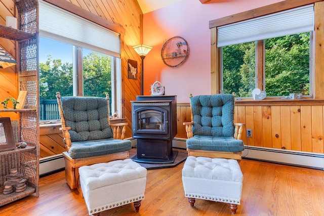 252 General Turner Hill Rd, Turner, ME 04282 - living area featuring a baseboard radiator, wooden walls, and a wood stove