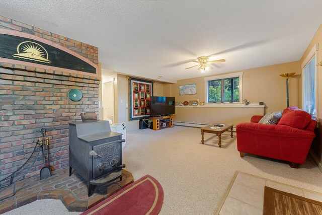 252 General Turner Hill Rd, Turner, ME 04282 - living room featuring a wood stove, a textured ceiling, a ceiling fan, baseboard heating, and carpet flooring