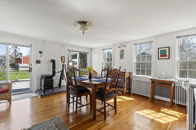 dining area with plenty of natural light, radiator heating unit, and a wood stove