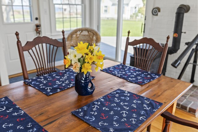 dining space with a wood stove and wood finished floors