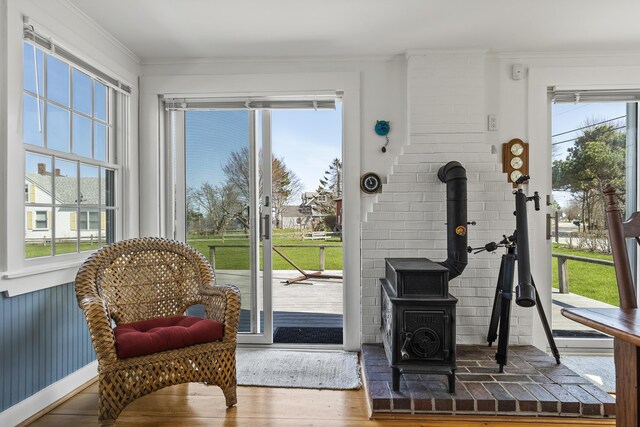 interior space featuring crown molding, wood finished floors, and a wood stove