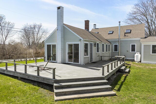 rear view of house with a lawn, a chimney, and a deck