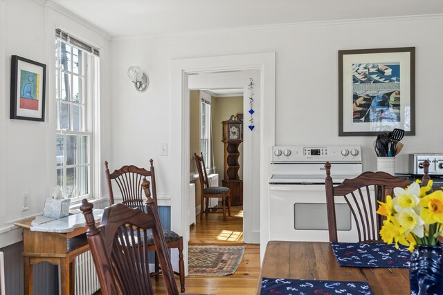 dining room featuring ornamental molding, wood finished floors, and a toaster