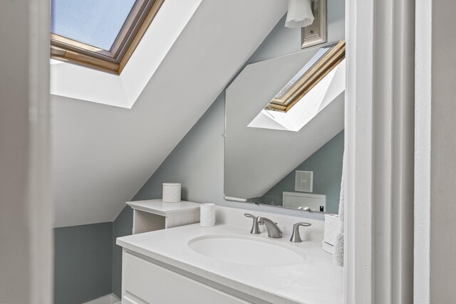 bathroom with visible vents, lofted ceiling with skylight, and vanity