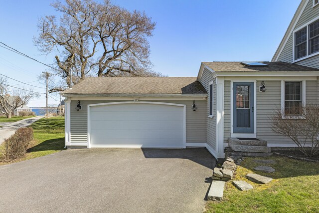 view of front of home featuring a garage, entry steps, driveway, and roof with shingles