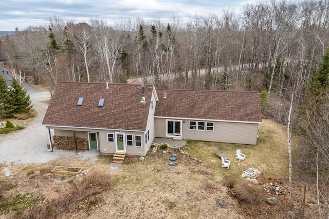 back of property featuring a chimney, roof with shingles, and entry steps