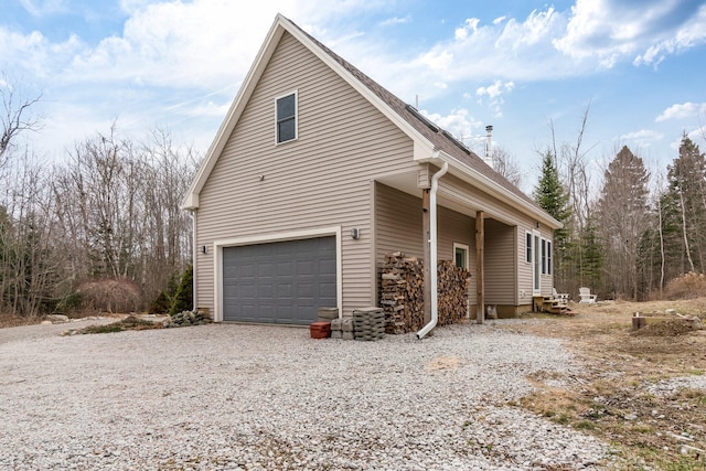 view of side of property featuring an attached garage and driveway
