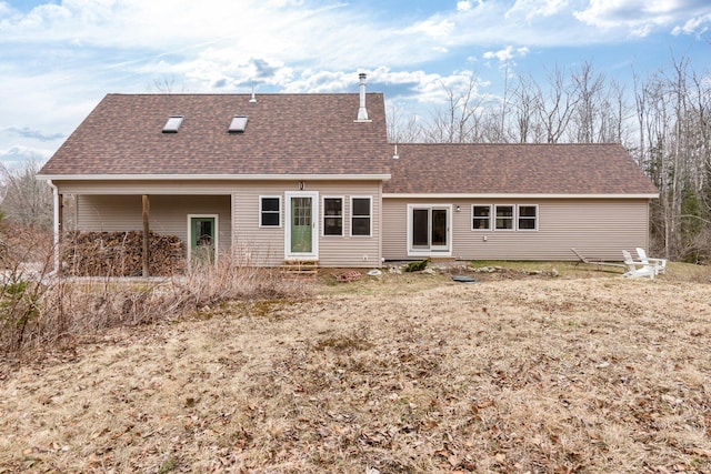 back of property with entry steps and a shingled roof