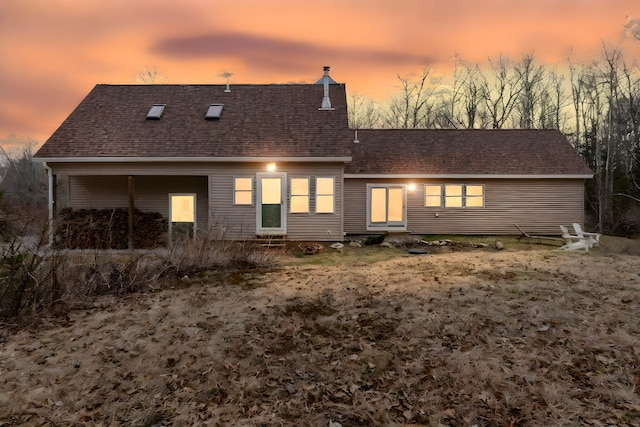 rear view of property with roof with shingles