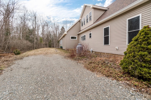 view of side of property with gravel driveway