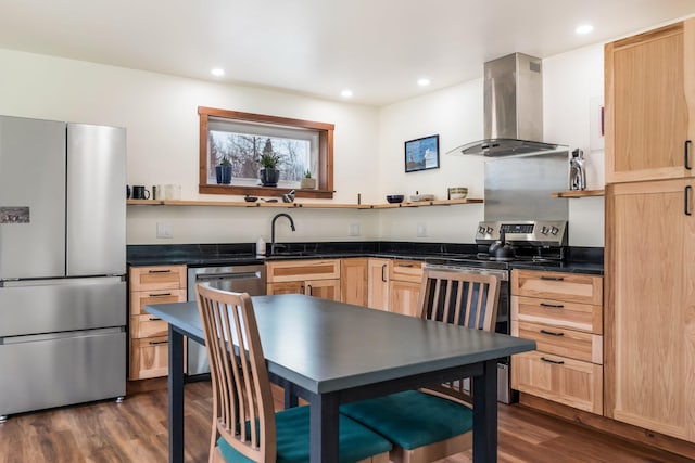 kitchen featuring dark countertops, open shelves, light brown cabinetry, wall chimney exhaust hood, and appliances with stainless steel finishes