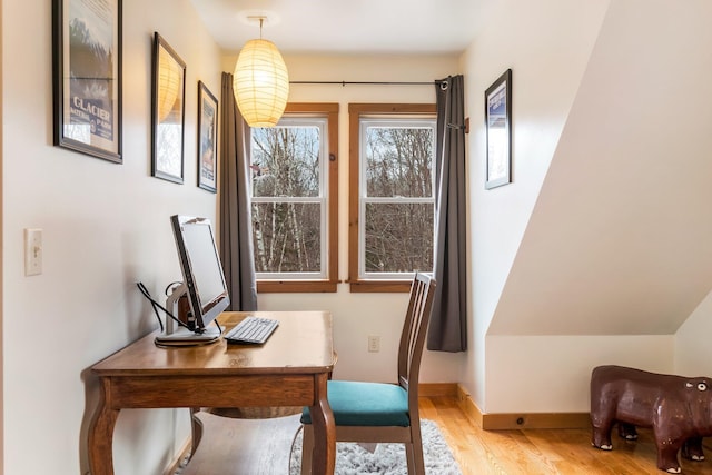 home office with light wood-style flooring and baseboards