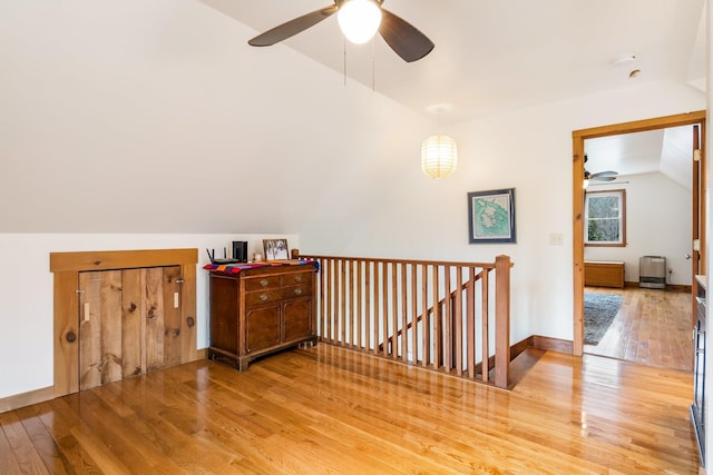 bonus room with baseboards, vaulted ceiling, wood finished floors, and ceiling fan