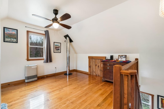 bonus room featuring light wood finished floors, vaulted ceiling, baseboards, and ceiling fan