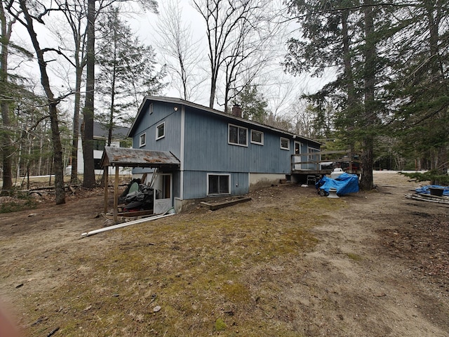 view of side of home with a wooden deck and a chimney