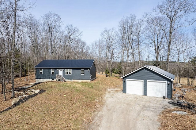 view of front of home featuring a garage, an outbuilding, and metal roof
