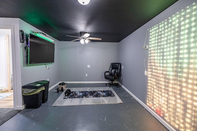 workout room featuring baseboards and ceiling fan
