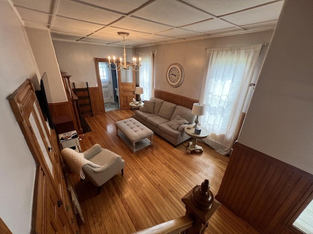 475 Main St, Van Buren, ME 04785 - living room with a wainscoted wall, a chandelier, wood finished floors, and wooden walls
