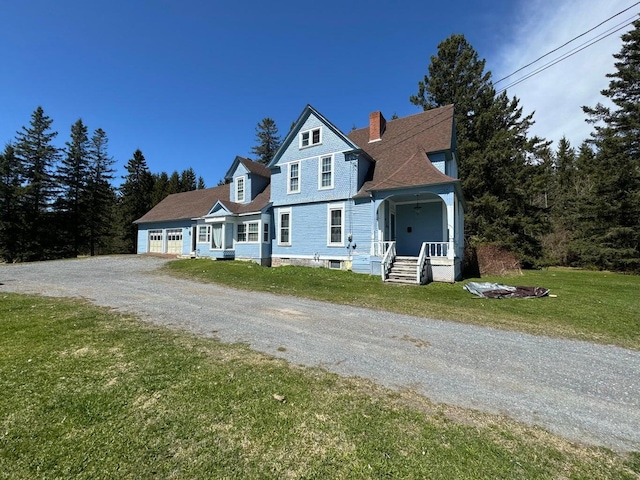 475 Main St, Van Buren, ME 04785 - view of front of house with a chimney, gravel driveway, a front lawn, a garage, and covered porch