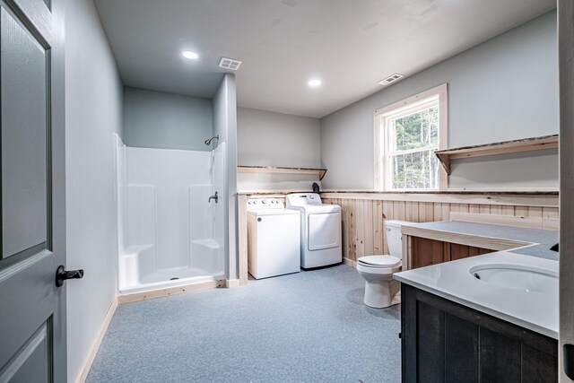 full bathroom with toilet, a wainscoted wall, visible vents, a shower, and washer and dryer