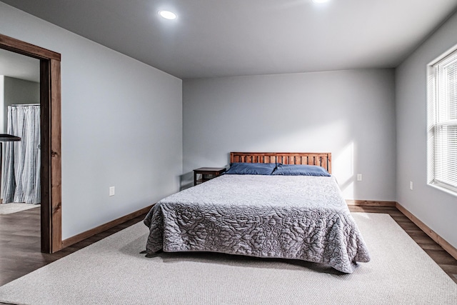 bedroom with wood finished floors, baseboards, and recessed lighting